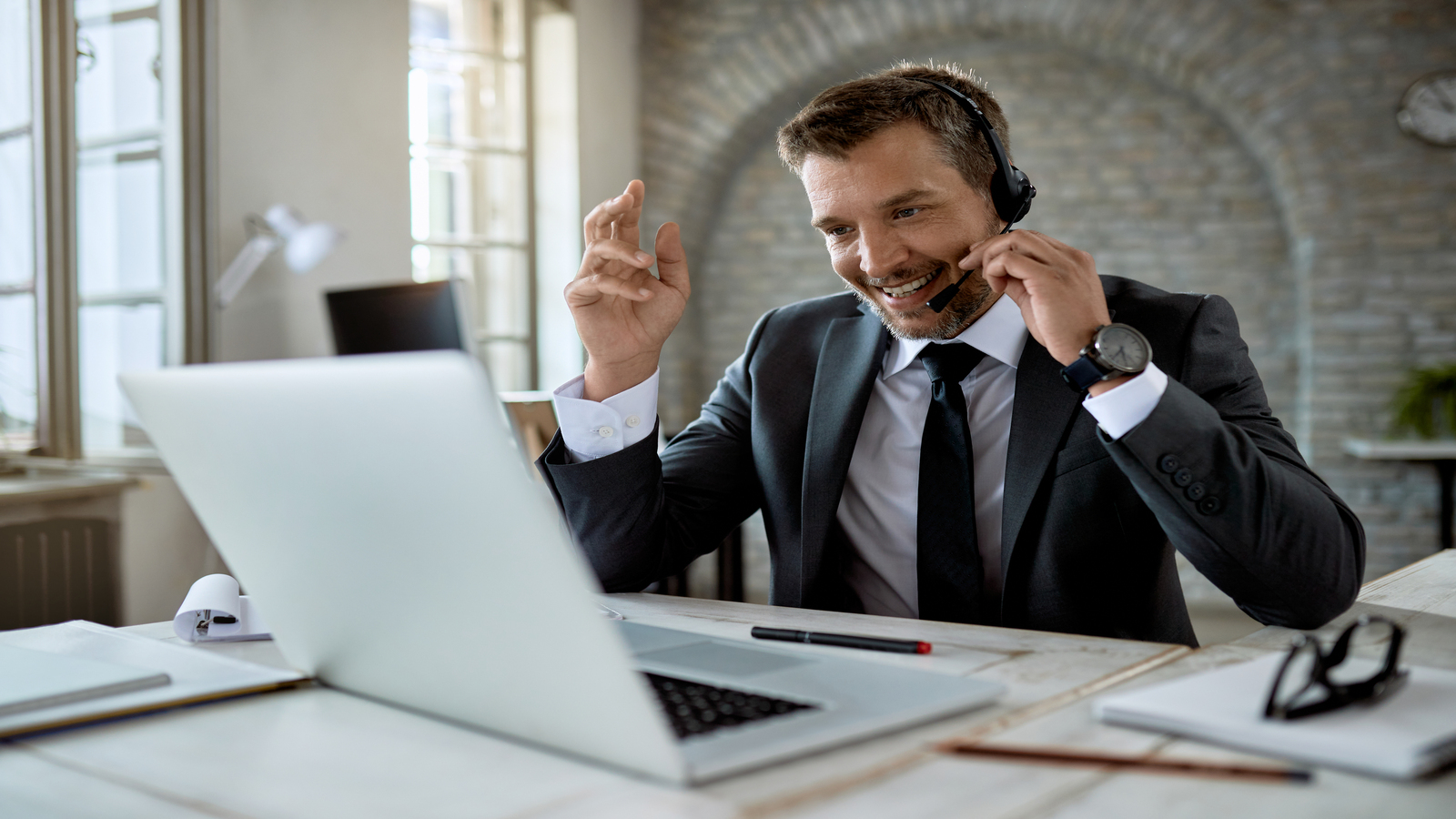 executivo usnado VoIP no Brasil para atender seu clientes em frente a computador em escritorio